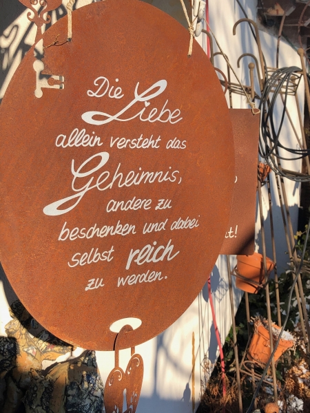 Schild "Die Liebe allein versteht das Geheimnis, andere zu beschenken und dabei selbst reich zu werden "